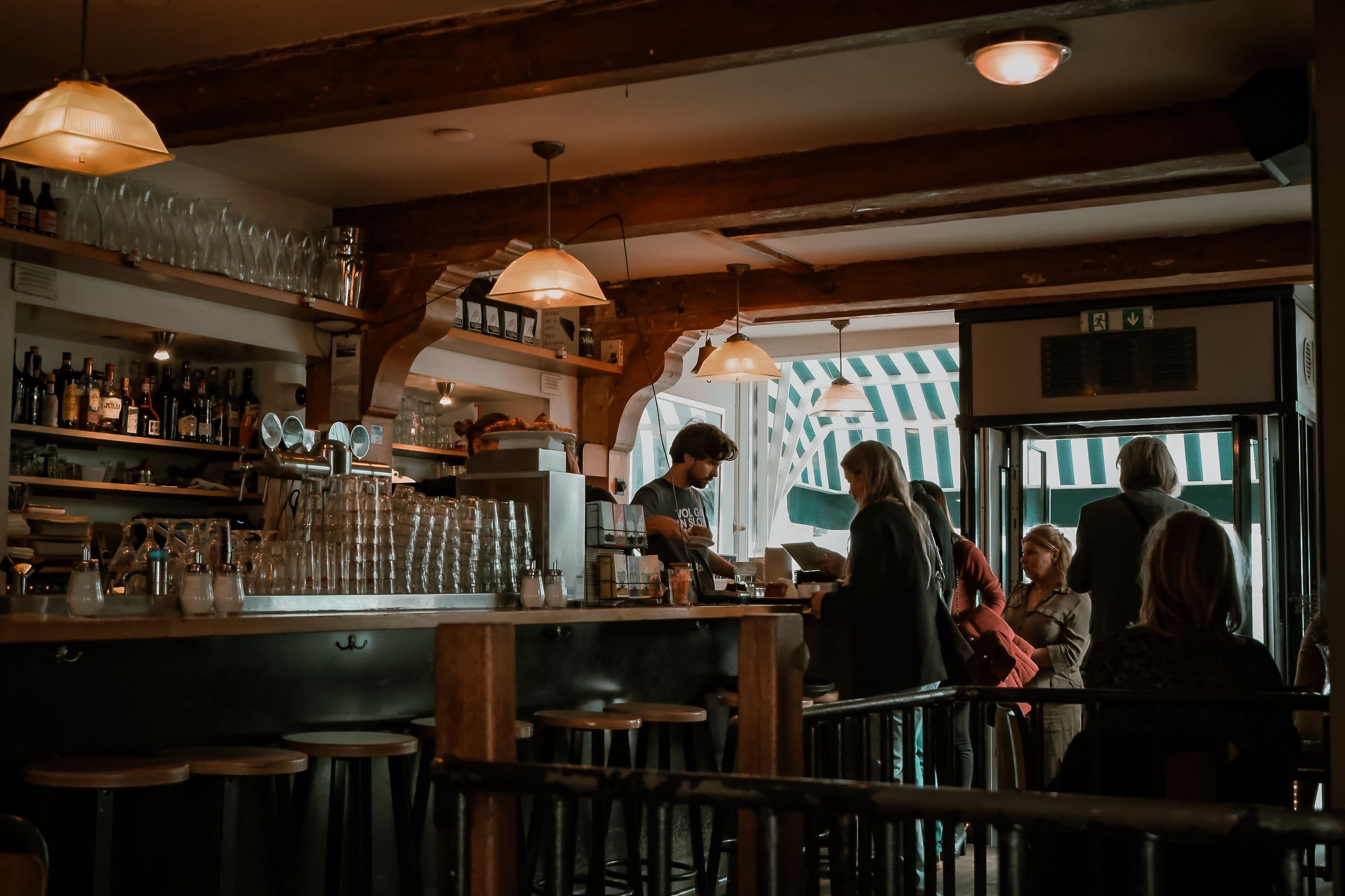 Interior de un restaurante con barra y clientes