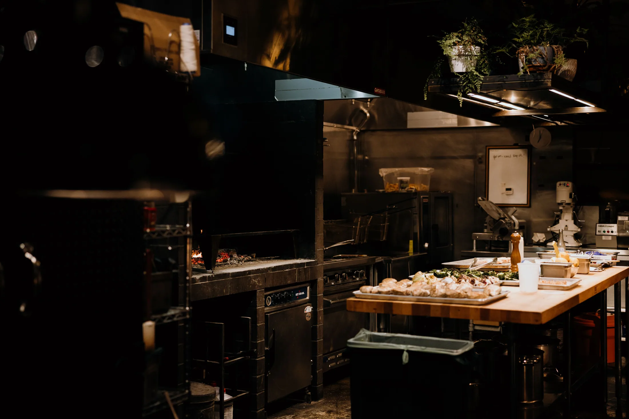Cocina abierta de un restaurante mediterráneo con fogón y una amplia estación de preparación